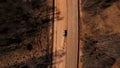 Truck with sand driving along unfinished road aerial