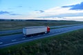 Truck with semi-trailer driving along highway on the sunset background. Goods delivery by roads. Services and Transport logistics Royalty Free Stock Photo