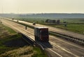 Truck with semi-trailer driving along highway on the sunset background. Goods delivery by roads. Services and Transport logistics Royalty Free Stock Photo