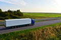 Truck with semi-trailer driving along highway on the sunset background. Goods delivery by roads. Services and Transport logistics Royalty Free Stock Photo