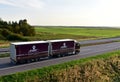 Truck with Semi-trailer by `ExportMegaTrans EMT` - freight forwarding company, driving along highway. Trucks traffic. Goods