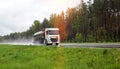 A truck with a semi-trailer tanker transports a dangerous cargo of fuel on a motorway slippery in the rain, industry