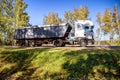 A truck with a semi-trailer transports bulk cargo grain in a special semi-trailer in autumn. Cargo transportation on