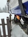 Truck slided too close to a fence during heavy snowfall. Slippery road due to snowstorm. Lorry in trouble during goods