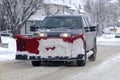 A truck with a snow plow attach to the front to clean the snow after a snow storm