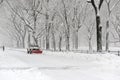 Truck with snowplow clearing road during snowstorm