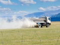 Truck spreading fertilizer on pasture meadow