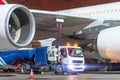 Truck with a tank of kerosene of aviation fuel connected to the fuel tanks of a large aircraft airliner, refueling service of a Royalty Free Stock Photo