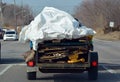 Truck towing trailer down street loaded with garbage Royalty Free Stock Photo