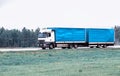 Truck tractor hitch with semi-trailer transports cargo on a country highway with a large tonnage and volume of cargo. Copy space