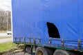 Truck trailer with blue damaged awning, cargo goods theft problem by cutting the awning, cut awning