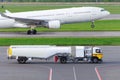 Truck with trailer tanker aviation fuel, airport services and airliner huge airplane take off