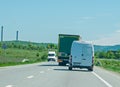 Truck transporting goods in traffic. It engages in a dangerous overtaking.