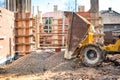 Truck unloading gravel with excavator and backhoe on construction site