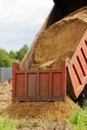 Truck unloads sand for backfilling trenches with the pipeline after the accident.