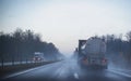 A truck wagon rides on a motorway in fog and rain. The concept of poor visibility on the road, copy space