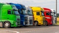 Trucks with containers in the parking lot along the highway against the background of clouds. The concept of logistics, transport Royalty Free Stock Photo