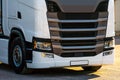 Trucks with containers in the parking lot along the highway against the background of clouds. The concept of logistics, transport Royalty Free Stock Photo