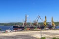 Trucks with grain waiting for unloading near the ship. Royalty Free Stock Photo