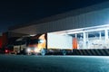 Trucks Loading Goods at Warehouse Port at Night. Trucks Loading Dock Warehouse. Freight Truck Logistic Royalty Free Stock Photo