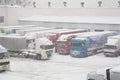 Trucks loading at warehouse and transport terminal. Parking in severe winter weather storm. Prohibition of traffic in heavy snow