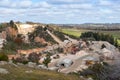 Trucks and machinery working at a stone quarry, exploitation of natural resources. Open air mining activity at Clare valley, South