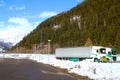 Trucks parking among snow beside highway in the mountains, Alps, south side, Switzerland Royalty Free Stock Photo