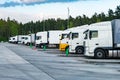 Trucks in a row with containers in the parking lot near forest , Logistic and Transport concept