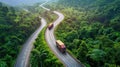 trucks running on curve asphalt road through green mountain.