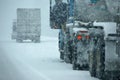 Trucks on winter highway during snowstorm