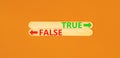 True or false symbol. Concept word True or False on beautiful wooden stick. Beautiful orange table orange background. Business and