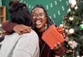 True friendship is a gift that lasts forever. two happy young women exchanging gifts during Christmas at home. Royalty Free Stock Photo