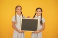 True information. Little girls hold writing surface yellow background. Children and chalkboard for writing information