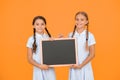 True information. Little girls hold writing surface yellow background. Children and chalkboard for writing information