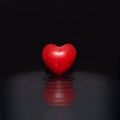 True love minimal concept. Red heart floating in black ripple water. Cool black background Royalty Free Stock Photo