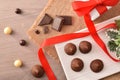 Truffles and chocolate portions on plate on table with gift
