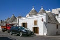 Trulli houses in Alberobello village with parked cars on the street Royalty Free Stock Photo