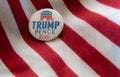 Trump-Pence 2020 campaign badge against United States flags.