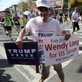 Trump supporter with political signs runs at New York City Marathon.