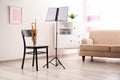 Trumpet, chair and note stand with music sheets Royalty Free Stock Photo