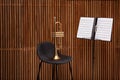 Trumpet, chair and note stand with music sheets Royalty Free Stock Photo