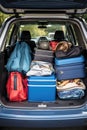 The trunk of a car full of suitcases and things. Travel by car.