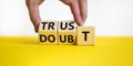 Trust or doubt symbol. Businessman turns wooden cubes and changes the word doubt to trust. Beautiful yellow table, white Royalty Free Stock Photo