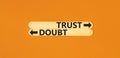 Trust or doubt symbol. Concept word Trust or Doubt on beautiful wooden stick. Beautiful orange table orange background. Business