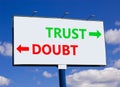 Trust or doubt symbol. Concept word Trust or Doubt on beautiful billboard with two arrows. Beautiful blue sky with clouds