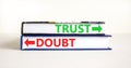 Trust or doubt symbol. Concept word Trust or Doubt on beautiful books. Beautiful white table white background. Business and trust