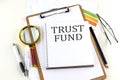 TRUST FUND text on notebook with clipboard on white background