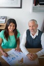 Trust them to get the job done. High angle portrait of two smiling colleagues working together at a desk in an office. Royalty Free Stock Photo