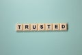 TRUSTED word with alphabet cubes isolated on Light Blue Background Royalty Free Stock Photo