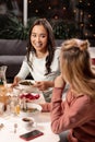 While dining in restaurant two girls sharing secrets with each other. Royalty Free Stock Photo